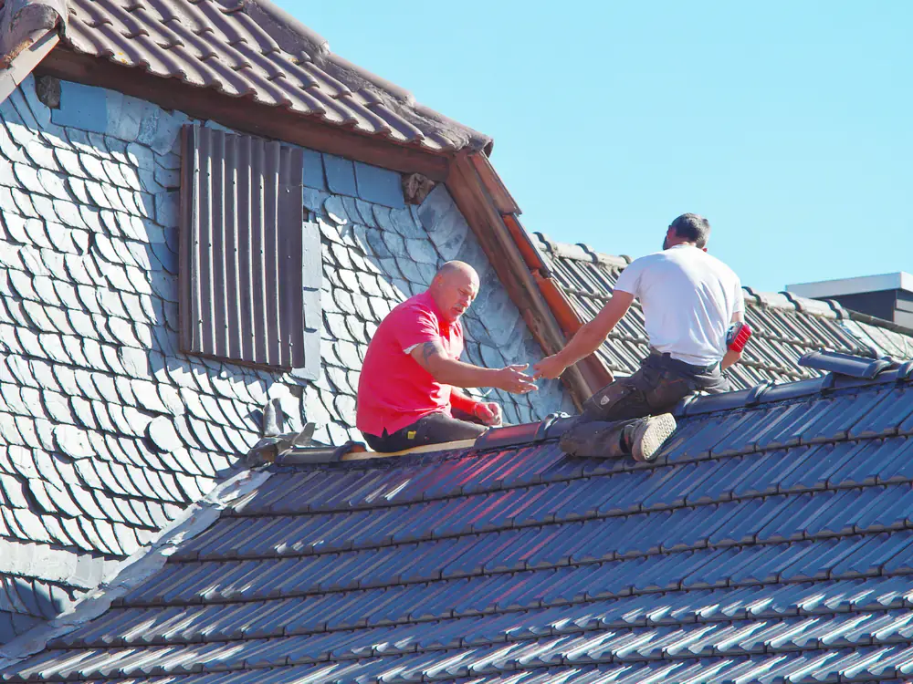 Dakdekkers aan het werk op een hellend dak